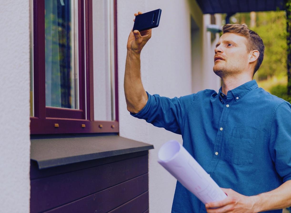 person with a phone taking image of a house center barnstead nh